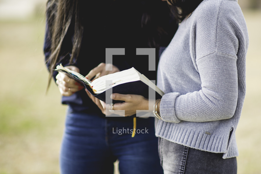 young women reading a Bible together 