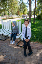 brothers sitting on a bench at a park 