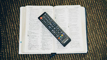 remote control on the pages of a Bible 