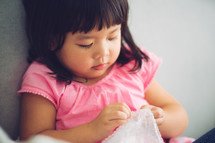child holding onto a blanket 