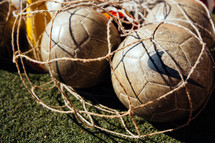 soccer balls in a a net bag 