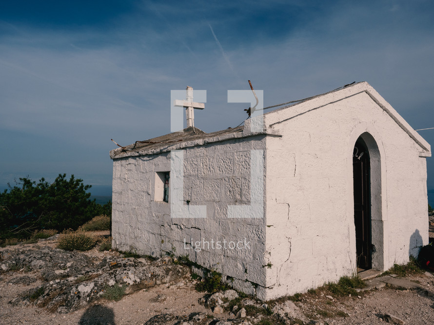 an old white stone chapel with a cross