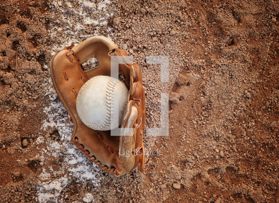 baseball glove and baseball on a baseball diamond 
