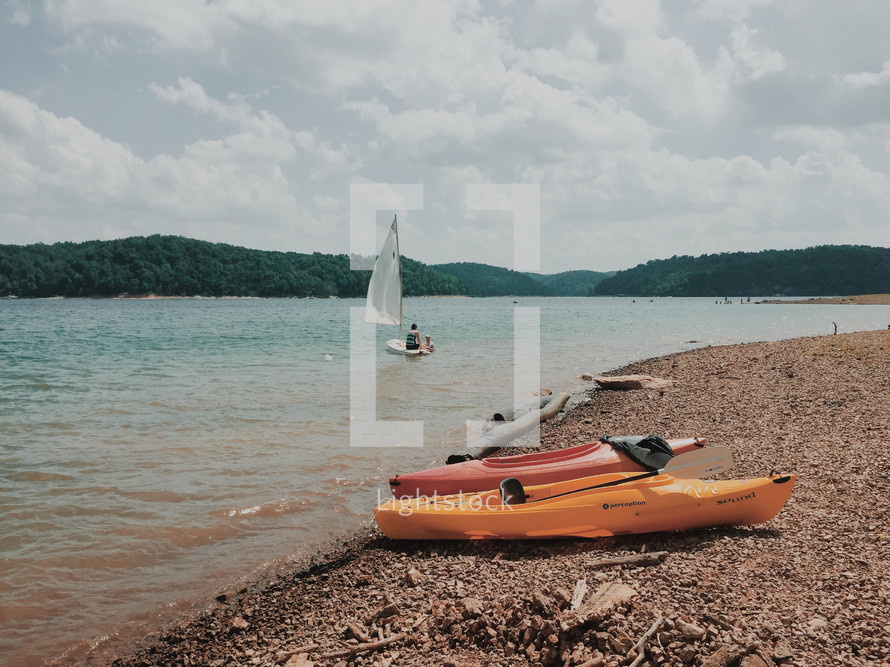 kayaks and sailboats on a lake 
