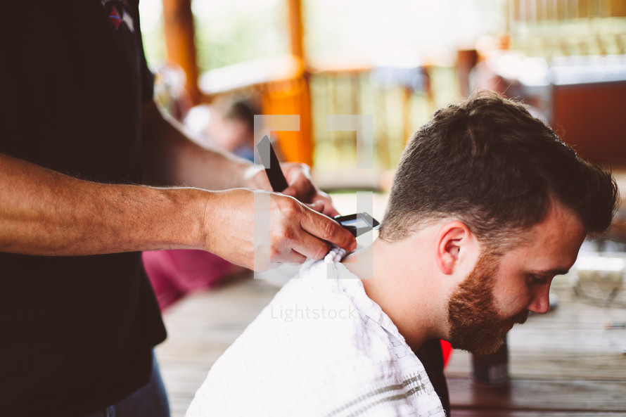 a man getting a haircut at a barbers shop 