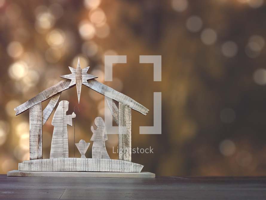 A simple nativity on a table with a bokeh background for adding text.