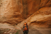 backpacking near a red rock cliff 