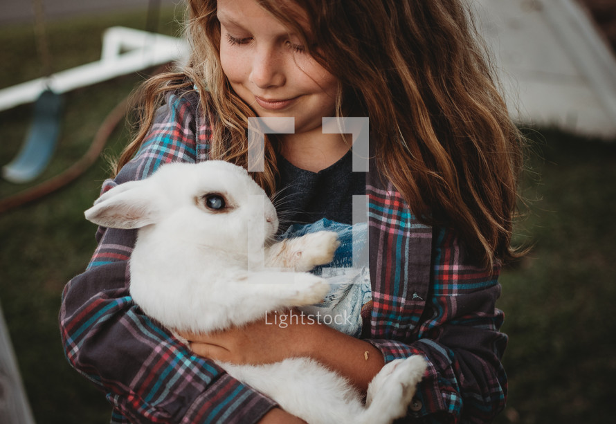 a child holding a rabbit 
