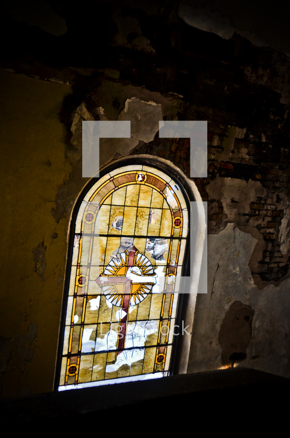 old and crumbling stained glass window in an abandoned church