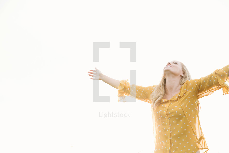woman standing outdoors with open arms