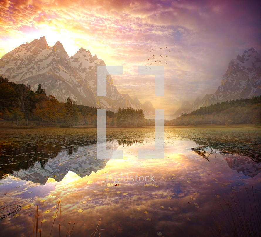  A beautiful sunrise over the tall mountains with a lake reflection