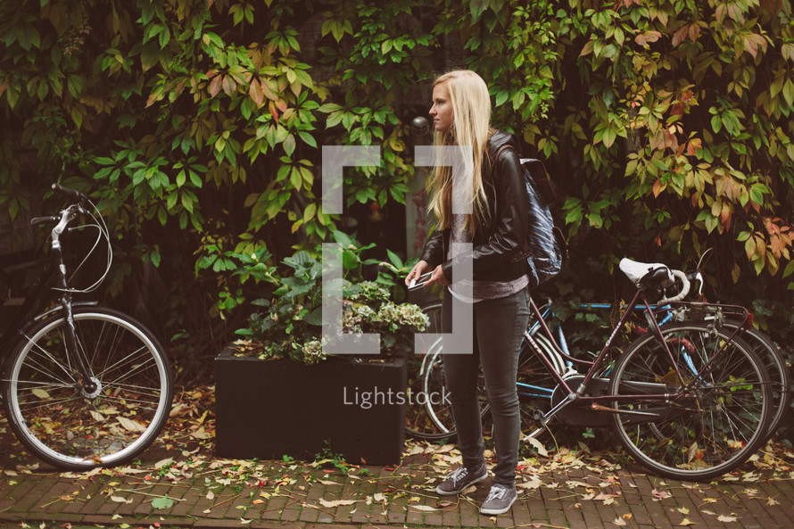 blonde woman standing next to a bicycle 
