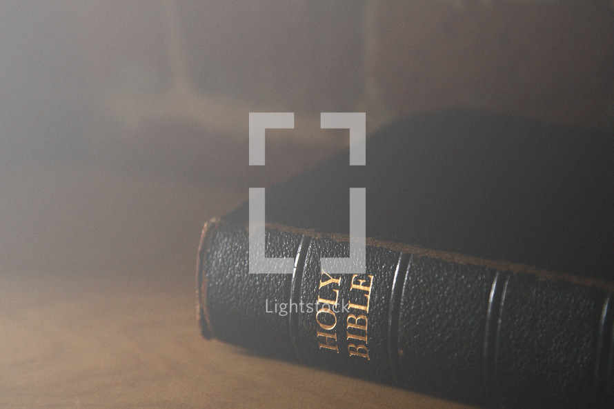 Light shining on a Bible on a table.