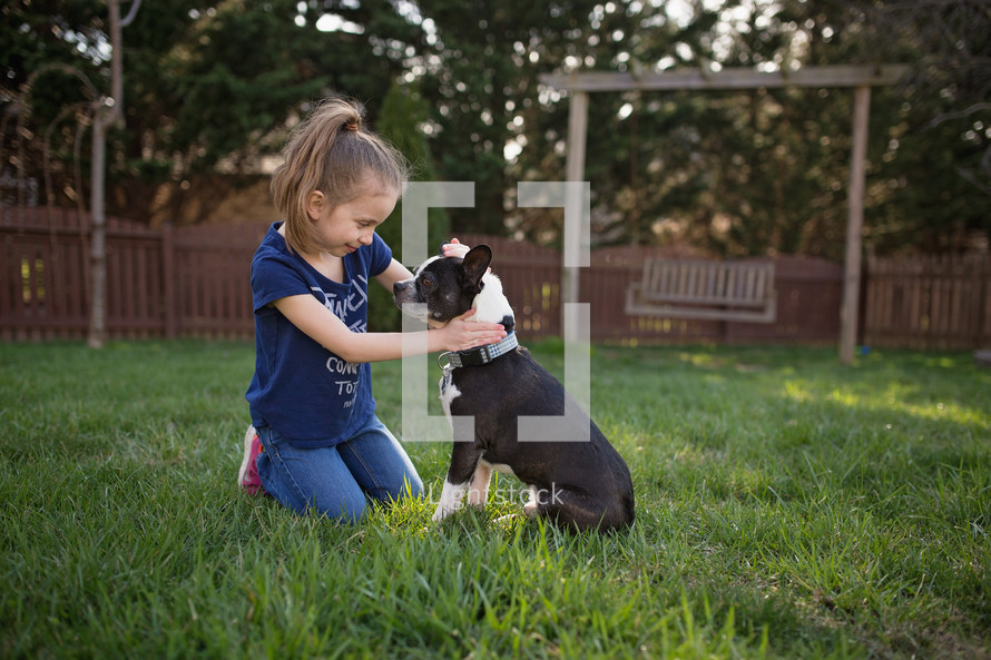 a girl in the backyard with her dog 