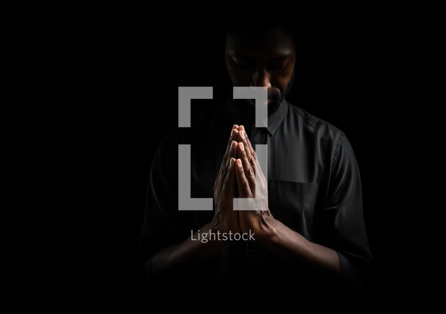 Black man praying on black background