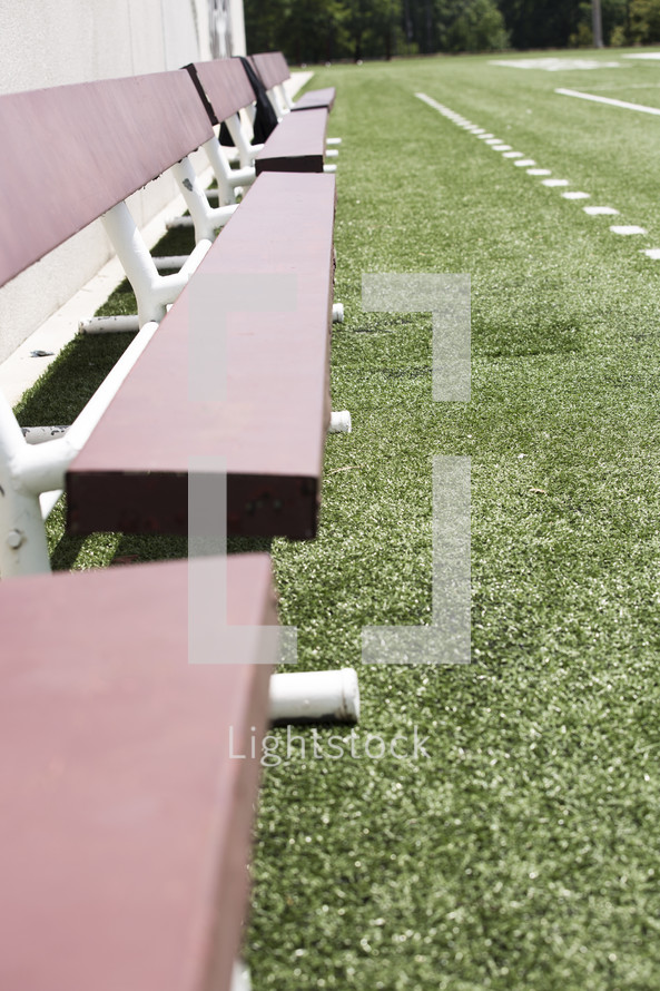 benches on the sidelines of a football field 