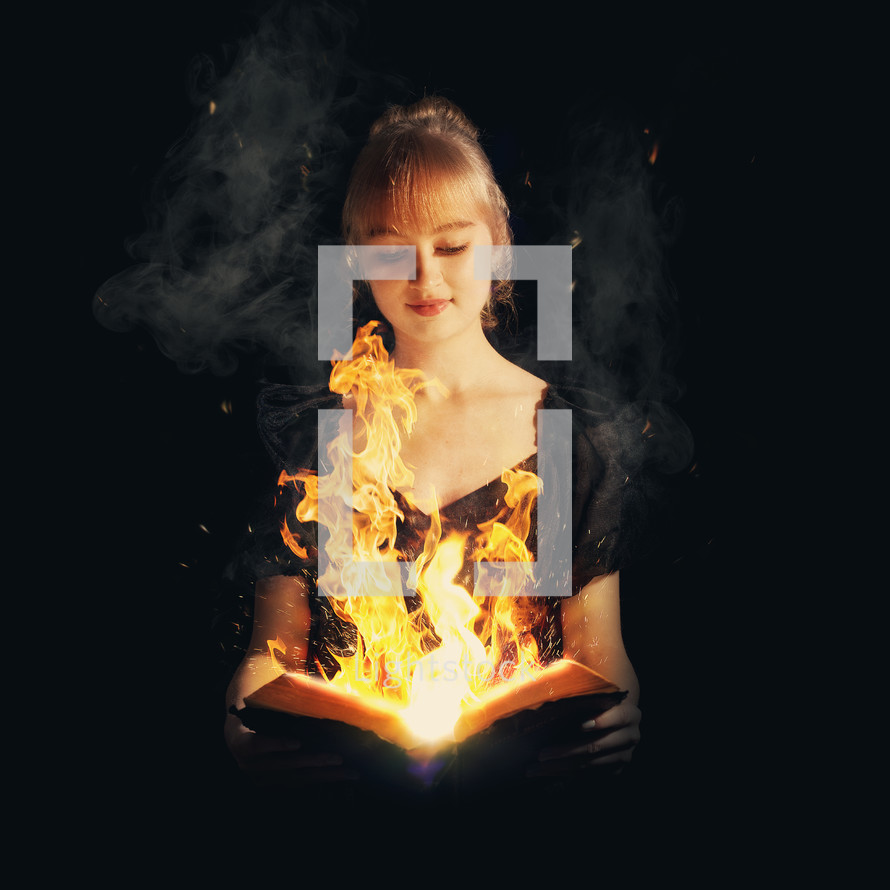 Girl holding an open Bible with flames emerging from the center of the pages.