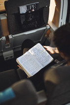 Girl reading her bible on en empty train.