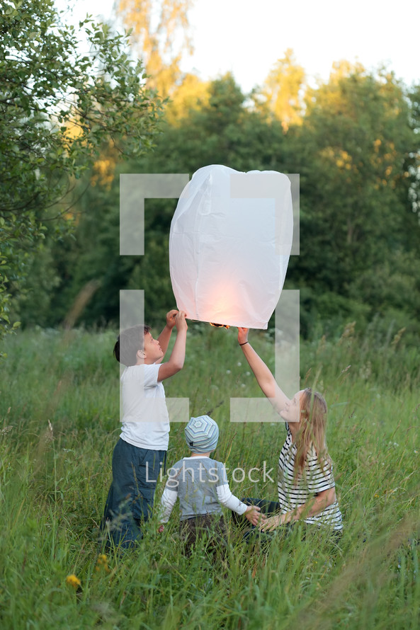 Family of three flying paper lantern outdoor