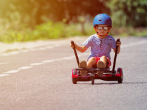 boy on hoverboard or gyroscooter with kart accessory kit outdoor. 