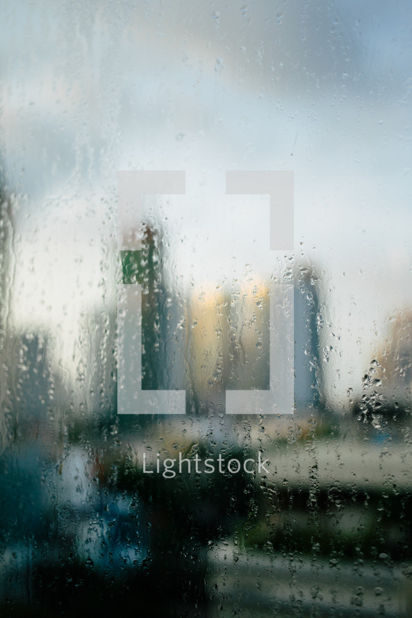 view of a city through a blurred wet and foggy window 