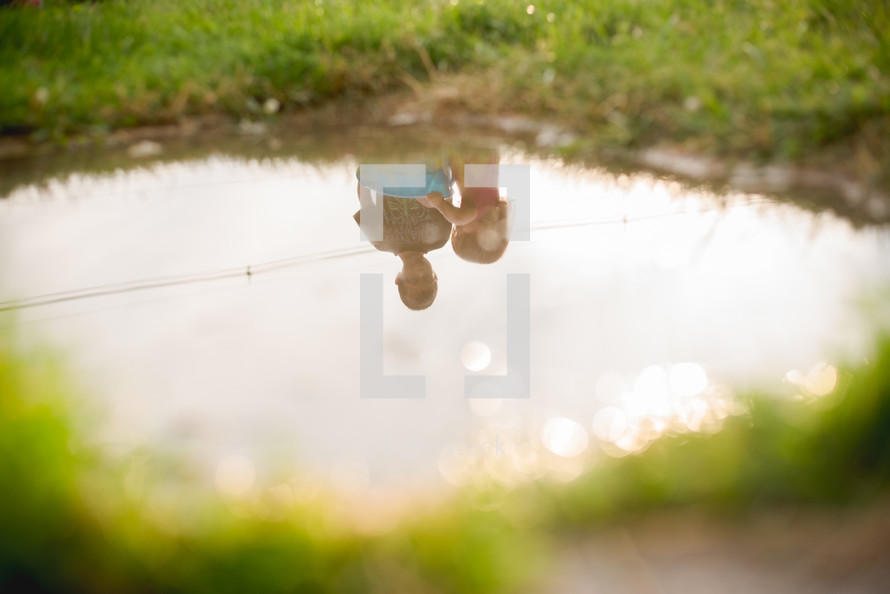 reflection of children in a puddle 