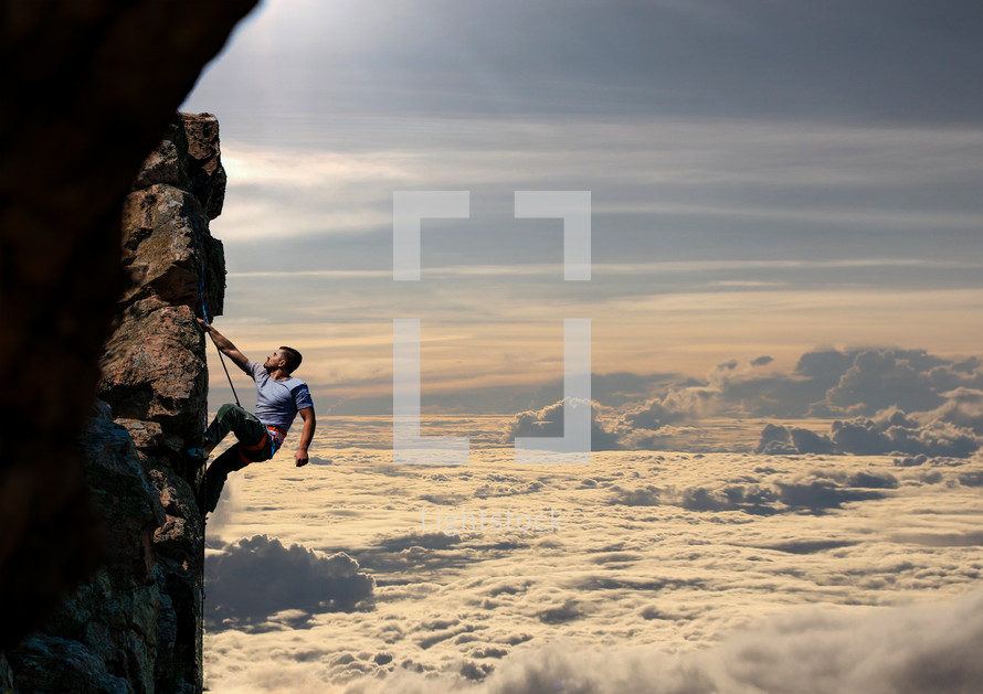 Man climbing a mountain with view above the clouds