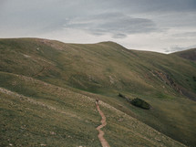 a man hiking a worn mountain trail 