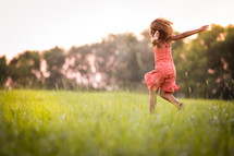 an excited girl running in grass 