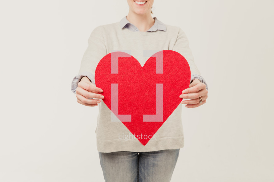 woman holding a red heart cut out 