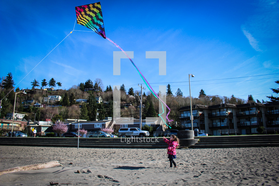 girl flying a kite in a coat 