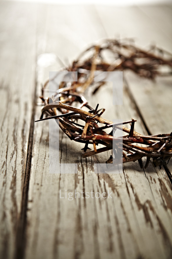 A crown of thorns on white washed wood planks.