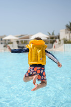 Boy jumping into pool in hotel in the Middle East