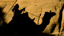 Man traveling on a journey riding a camel