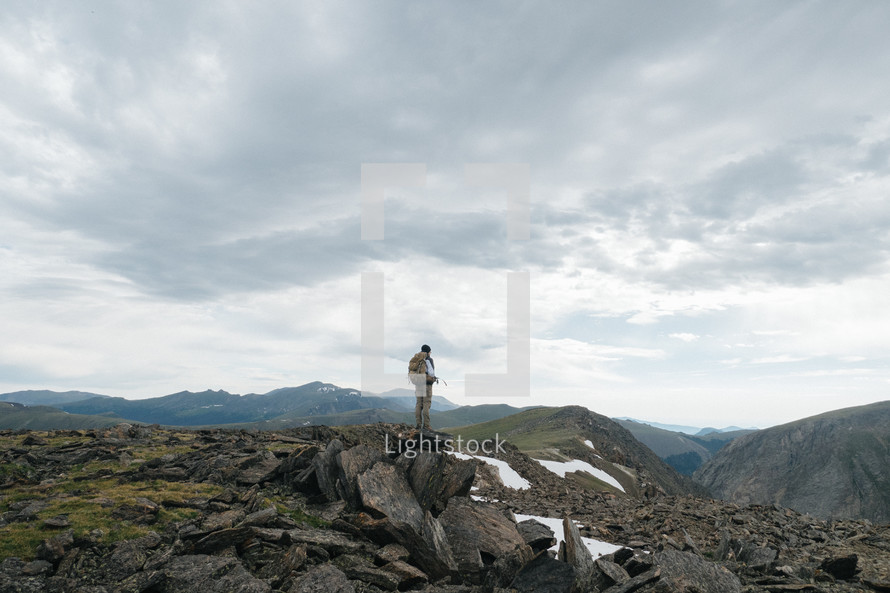 man standing on top of a rocky mountaintop 