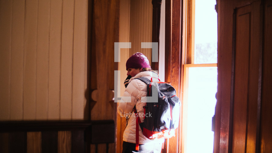 a woman bundled up standing in a ski lodge 