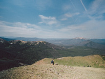 man sitting on a mountaintop 