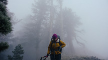 person hiking through a foggy mountainside forest 