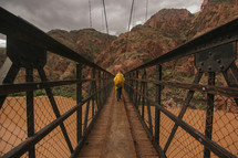 crossing a footbridge over a muddy river 
