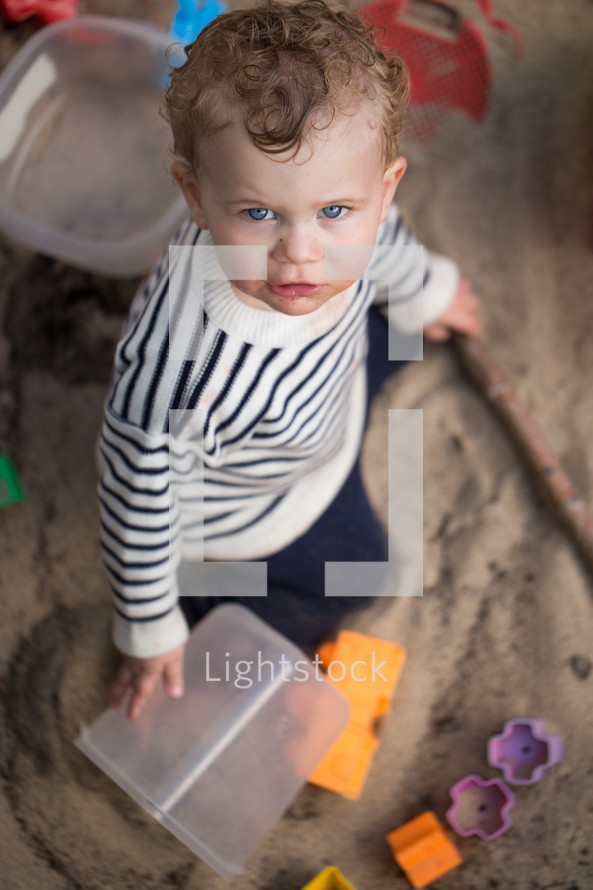 toddler boy playing in sand