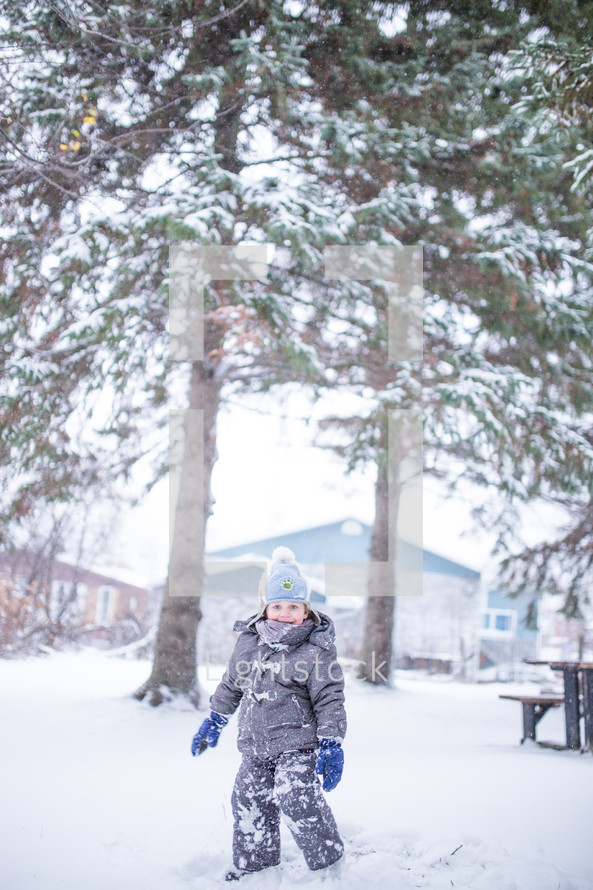 a boy child playing in snow 