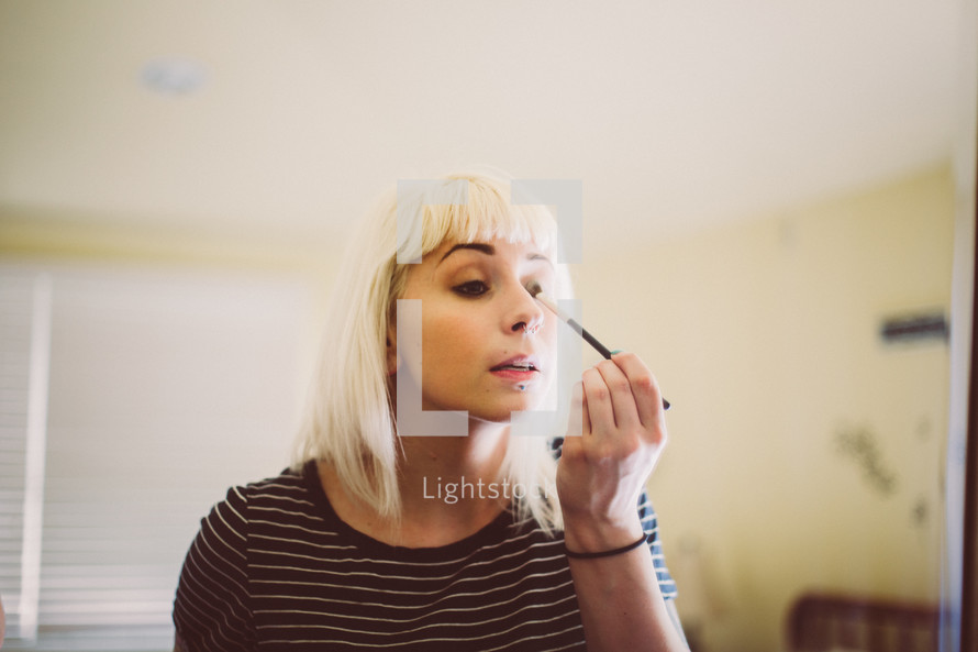 a woman putting on makeup 