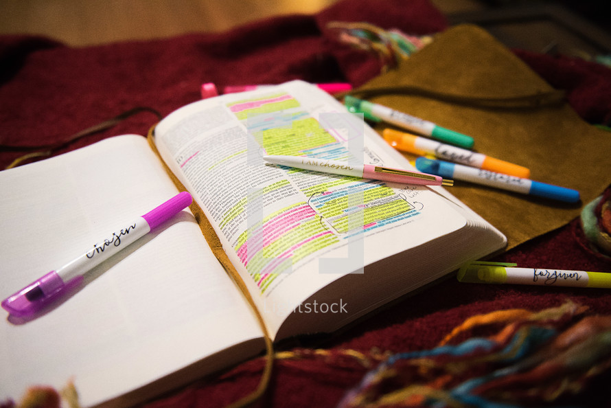 highlighters and pens on an open Bible 