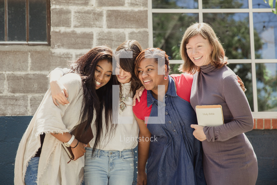 woman's group standing outdoors holding Bibles