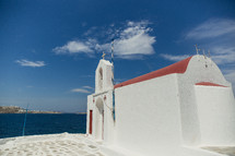 A small white stucco church by the sea.
