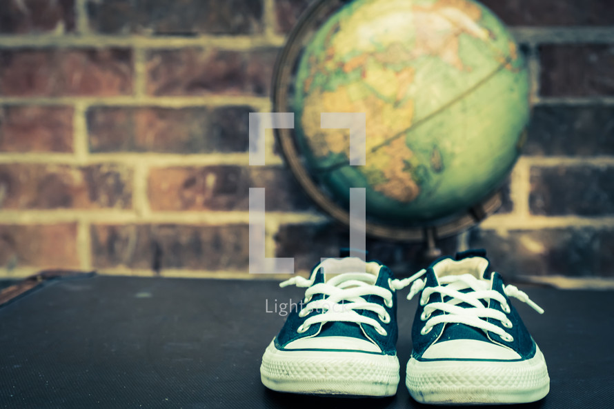 sneakers and globe on a trunk 