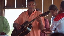 Man with guitar playing worship music in small church service