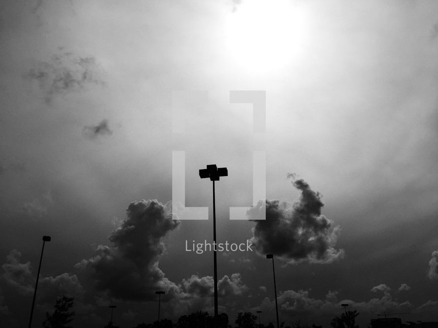 clouds in the sky and parking lot lamps 