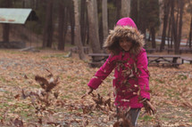 child playing in fall leaves 