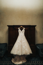 wedding gown hanging in a dressing room 